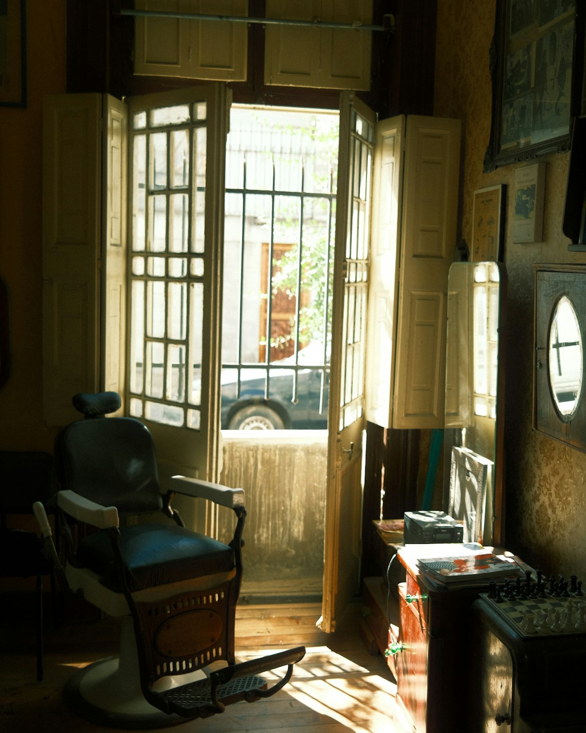 The three chairs and the mirror along the wall of the shop