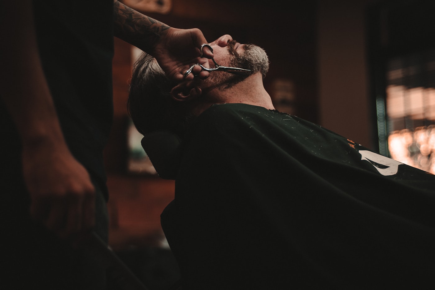 A barber finishing a fade at the first chair